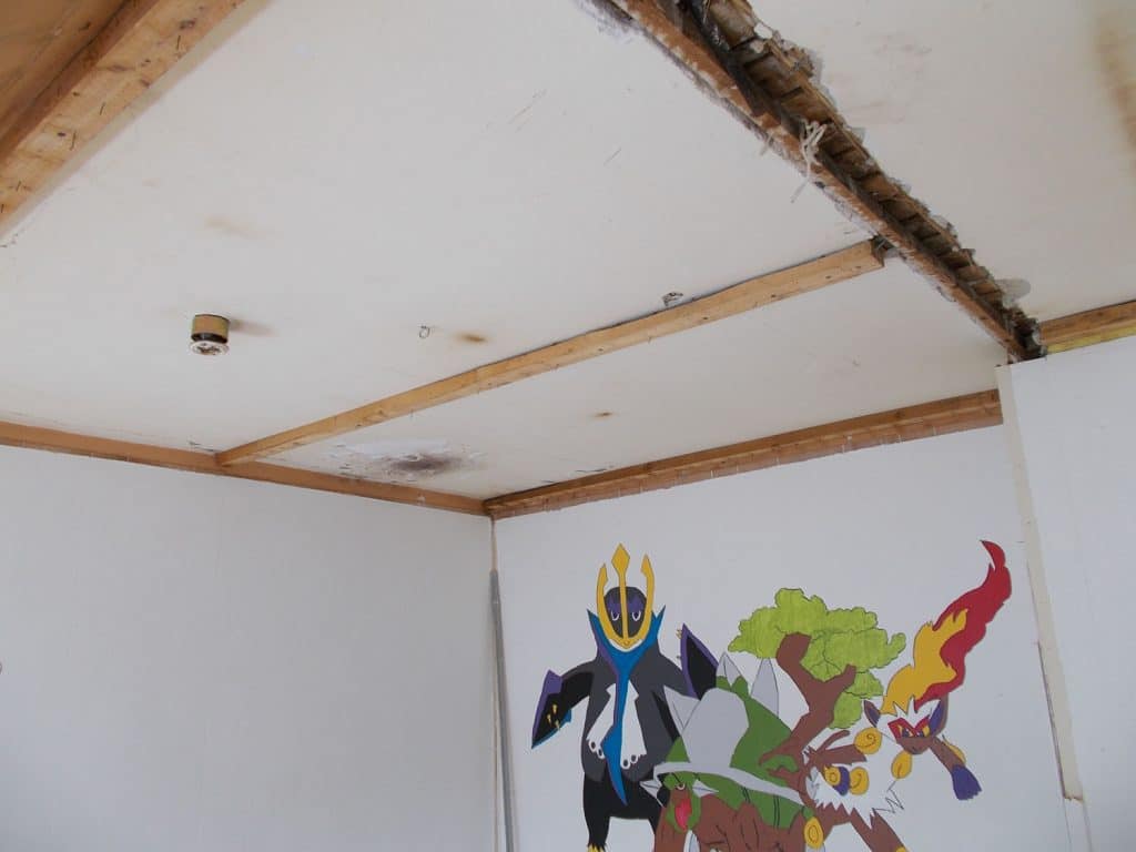 Loft i værelse med skader ved skråvæggen før udskiftning